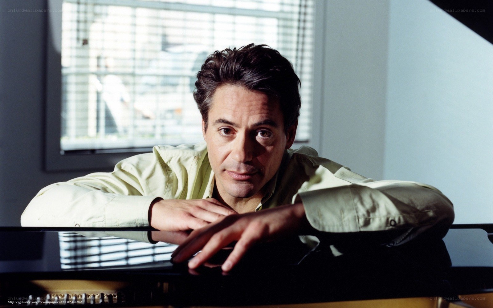 man leaning on piano