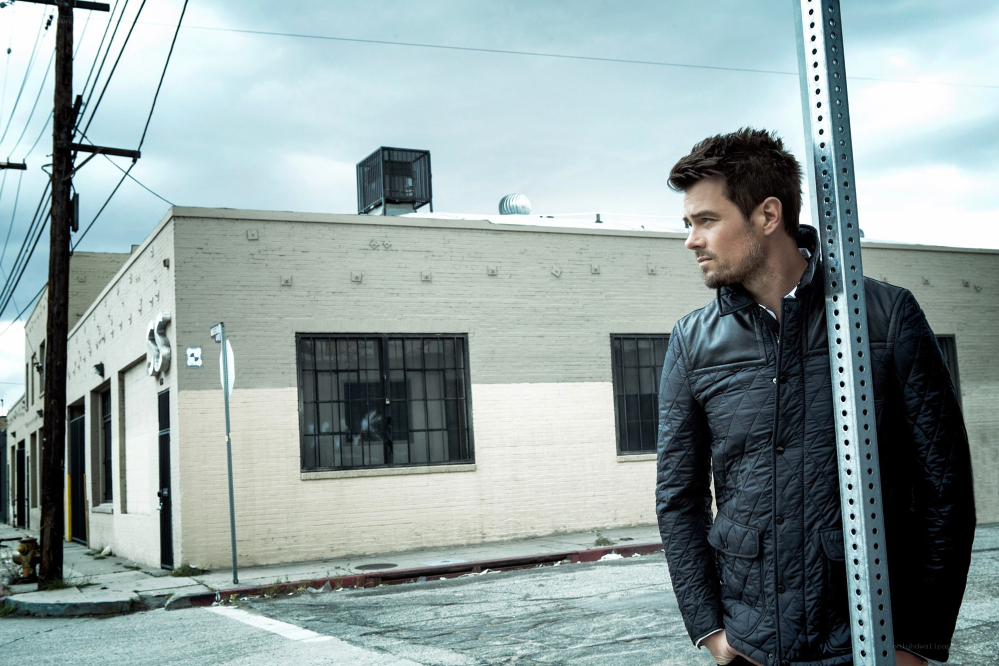 man leaning on pole in urban setting