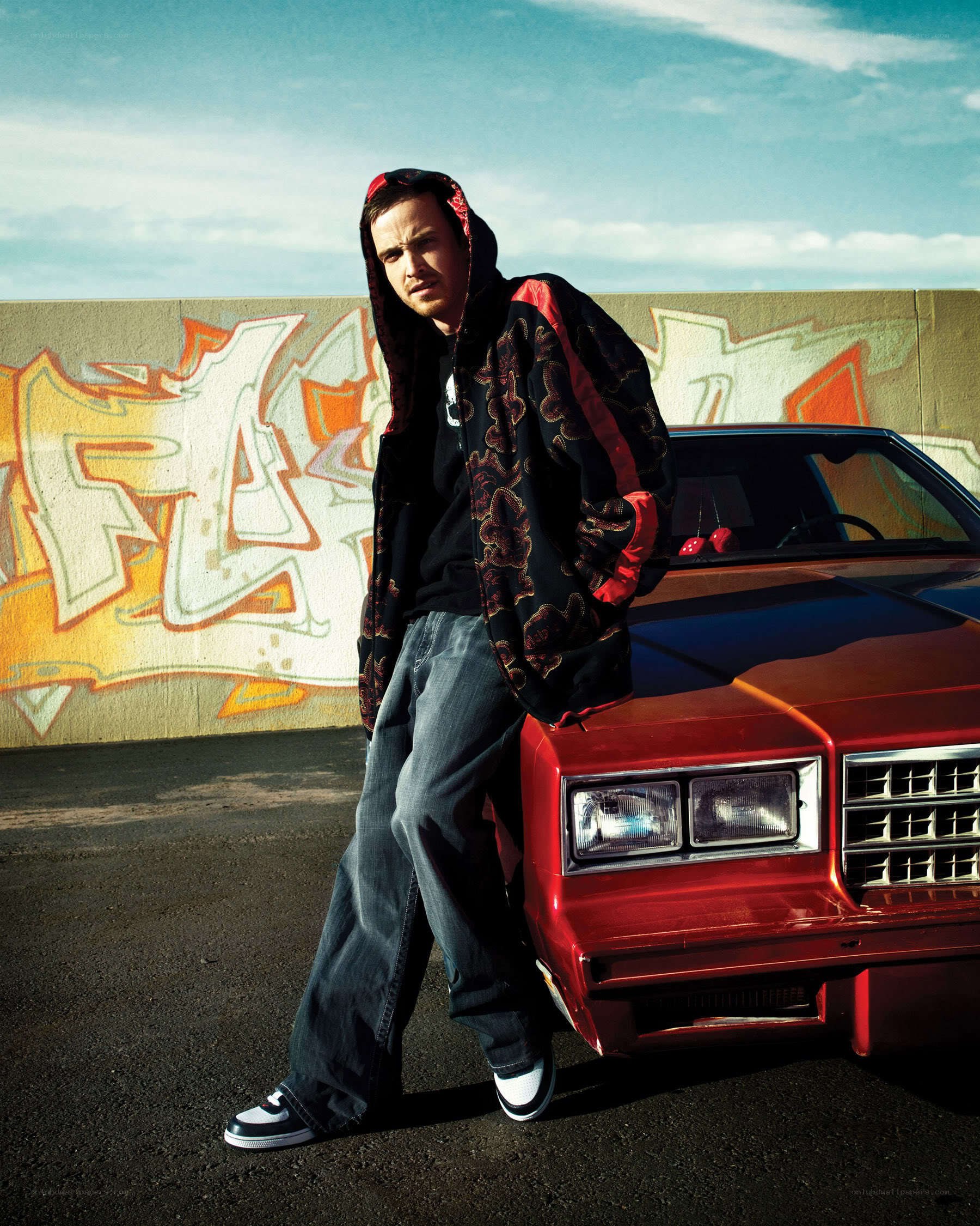 man leaning on red car