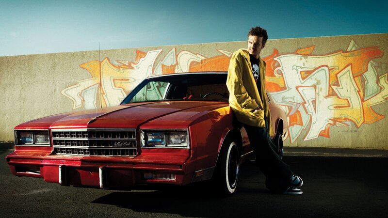 man leaning on red car