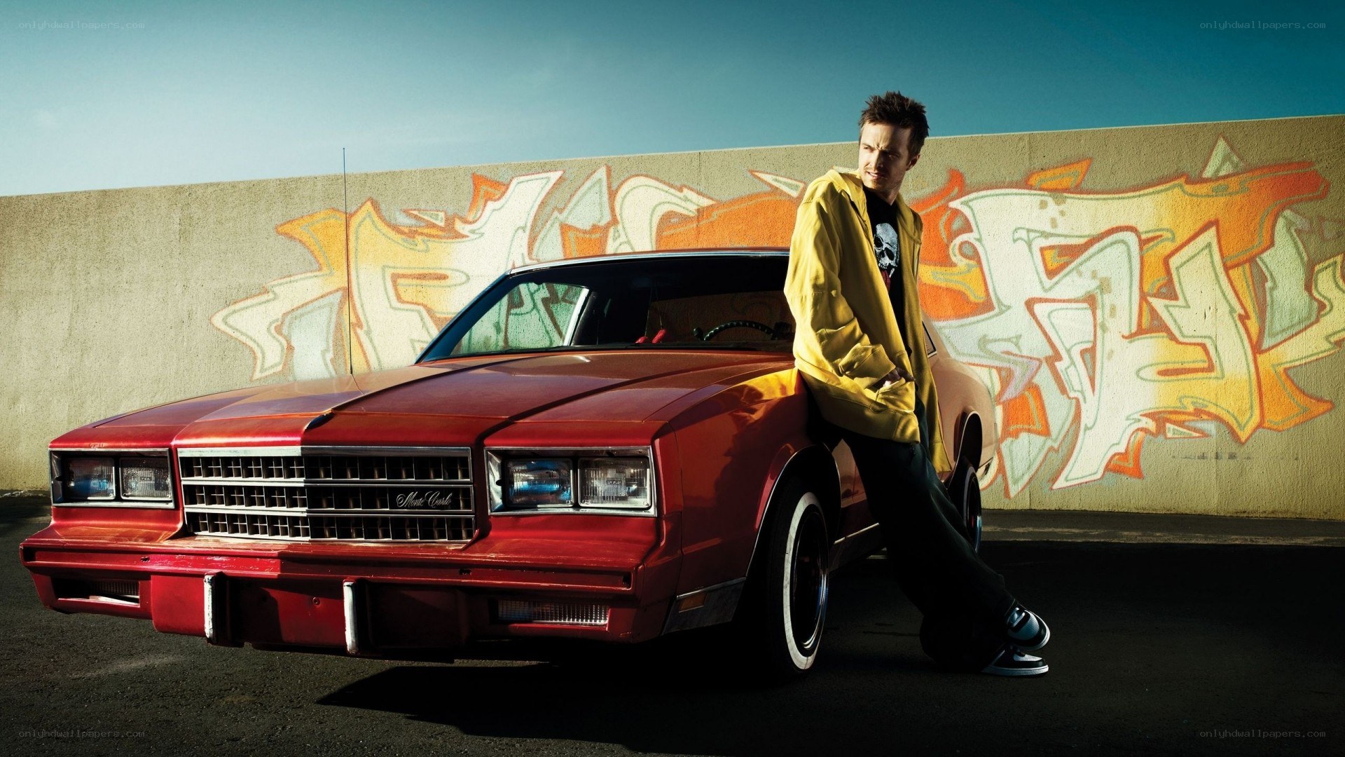 man leaning on red car