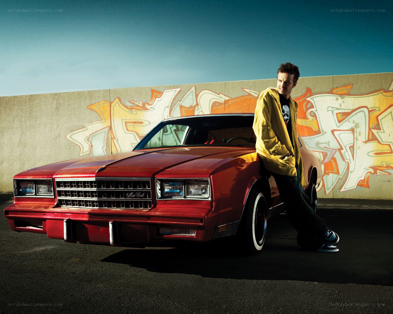 man leaning on red car