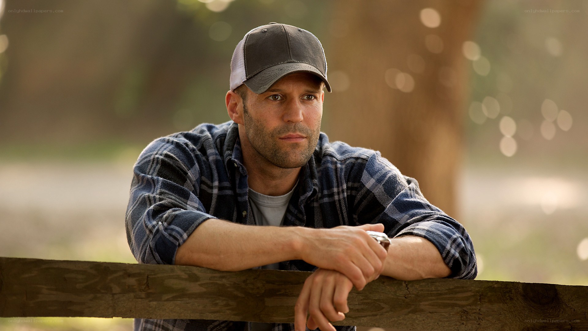 man leaning on wooden fence