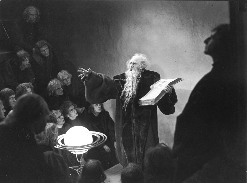 Man lecturing with book and model