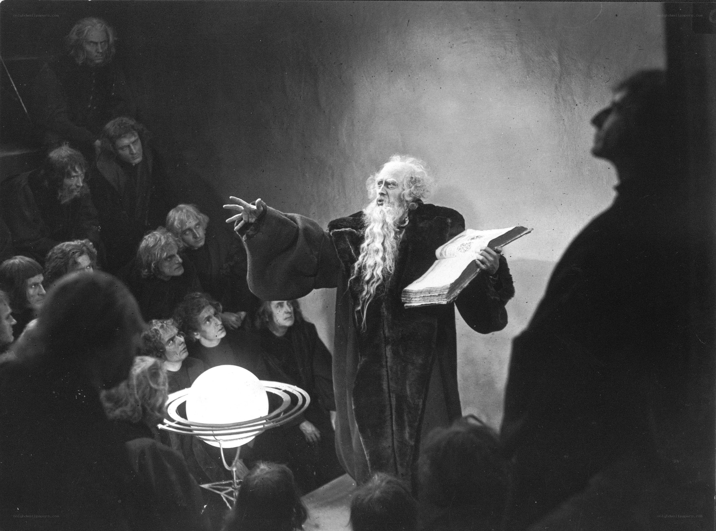 Man lecturing with book and model