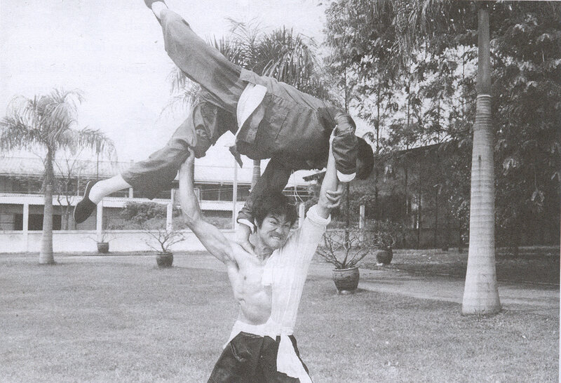 Man lifting another in martial arts pose