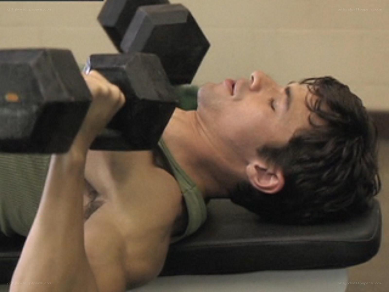 man lifting dumbbells at gym