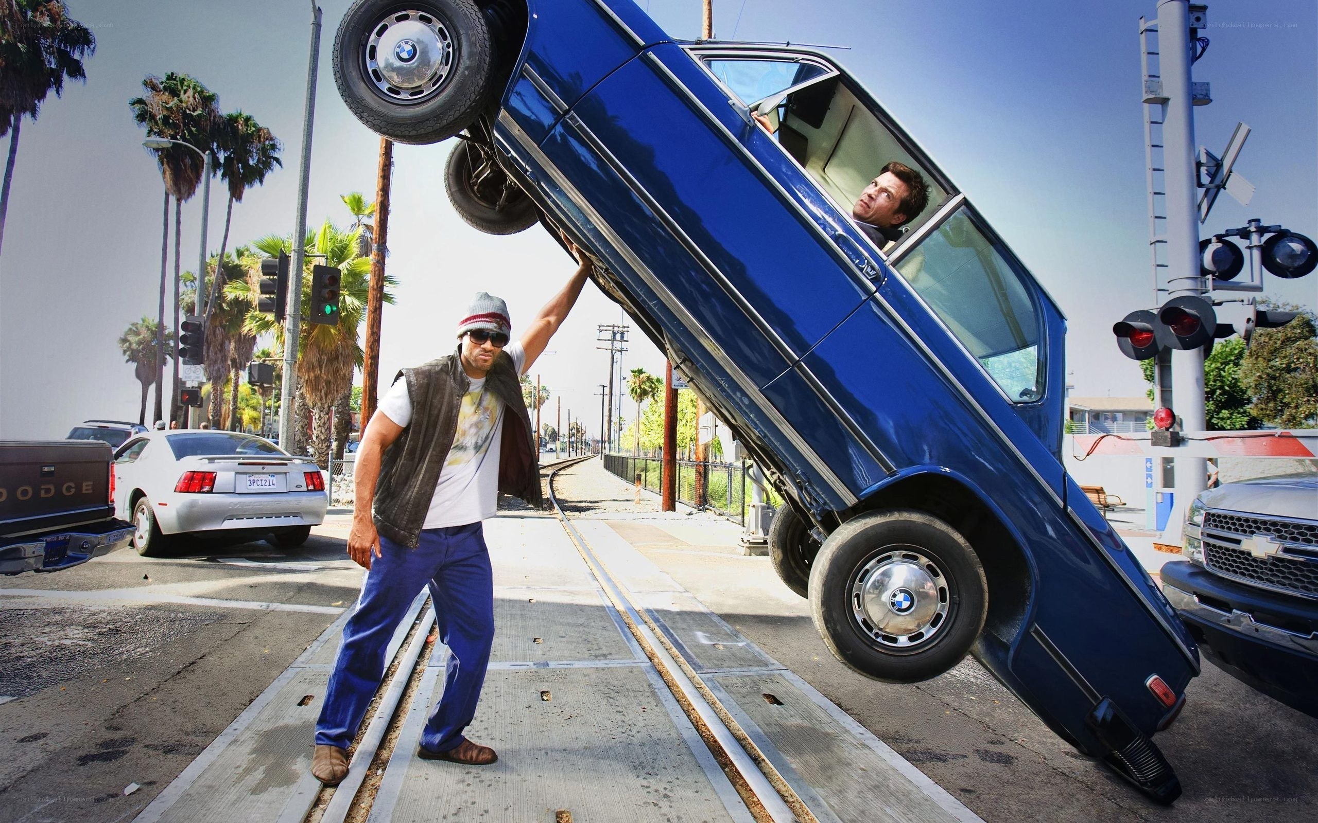 Man lifts car at train crossing