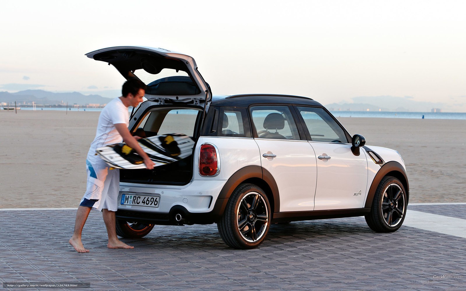 Man loading surfboard into car