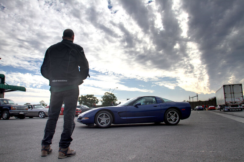 Man Looking at Blue Car