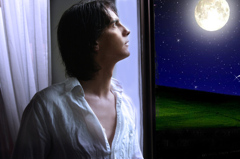 man looking at moon through window