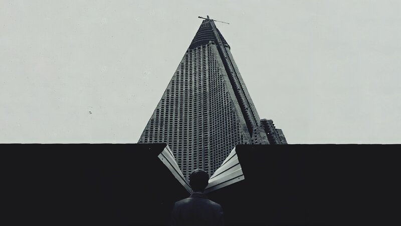 Man Looking at Pyramid Building