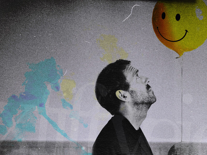 man looking at smiley balloon