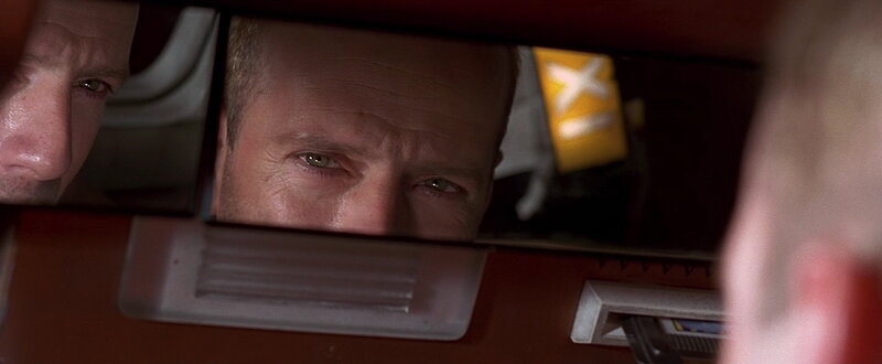 man looking in car mirror