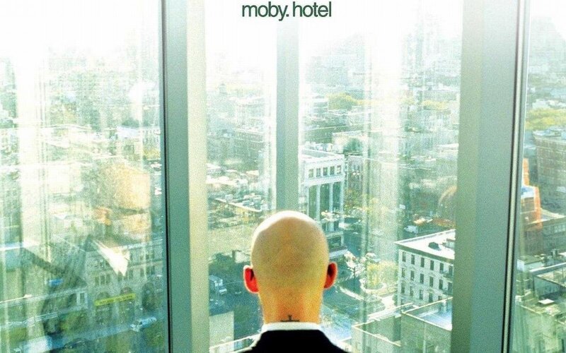 man looking out city window