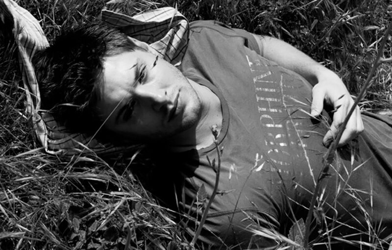 Man Lying in Grass — Black, Contemplative