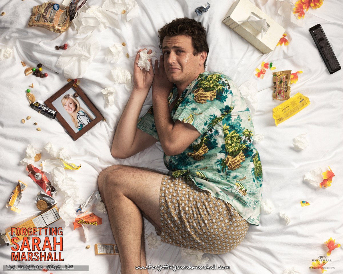 man lying on bed with snacks
