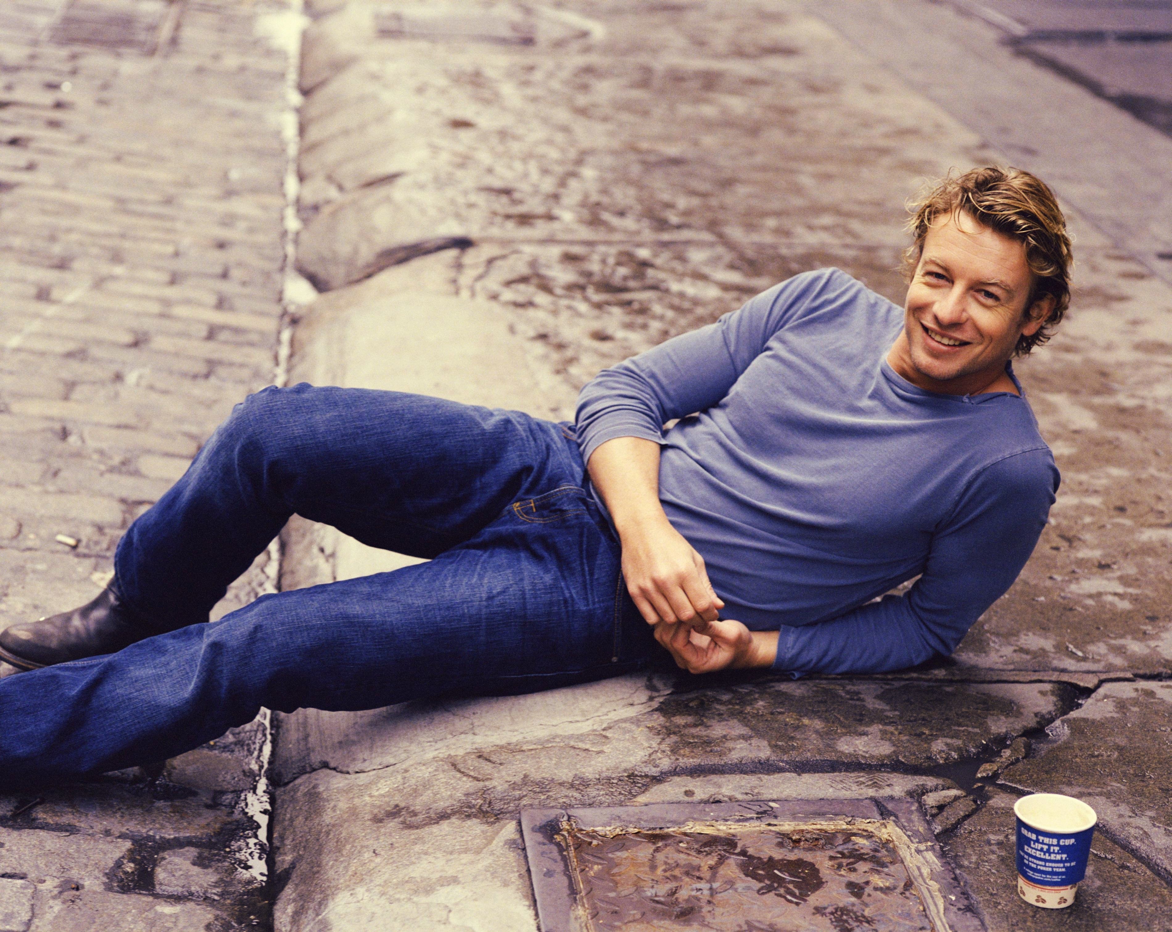 man lying on cobblestone street