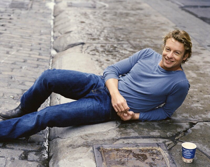man lying on cobblestone street