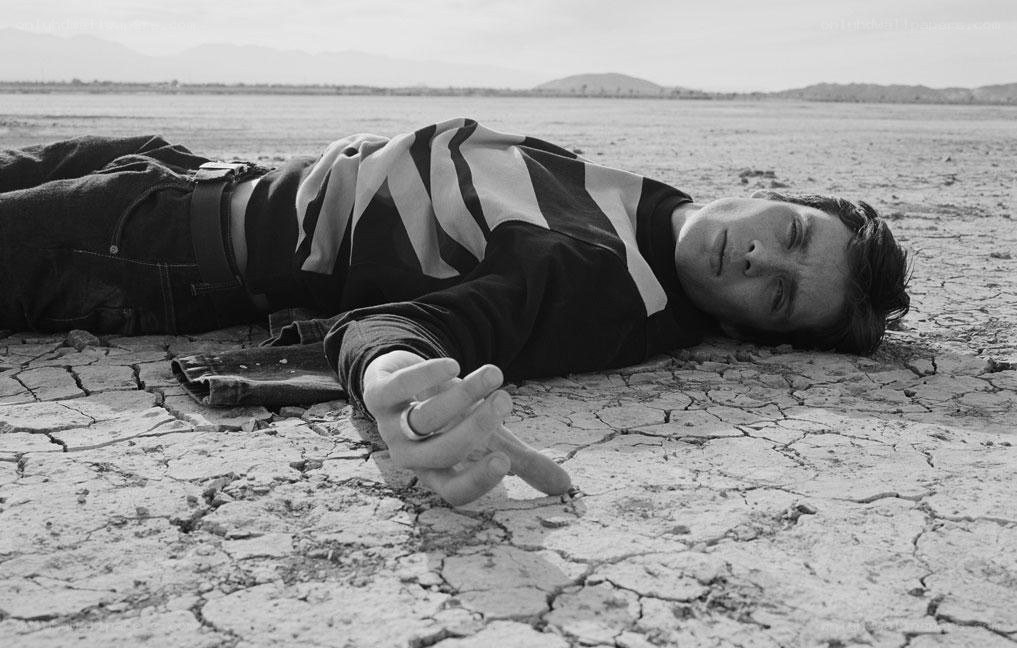 Man lying on cracked earth