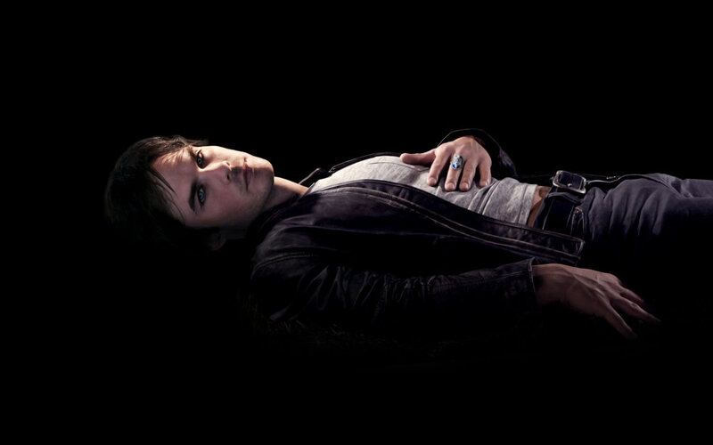 man lying on dark ground