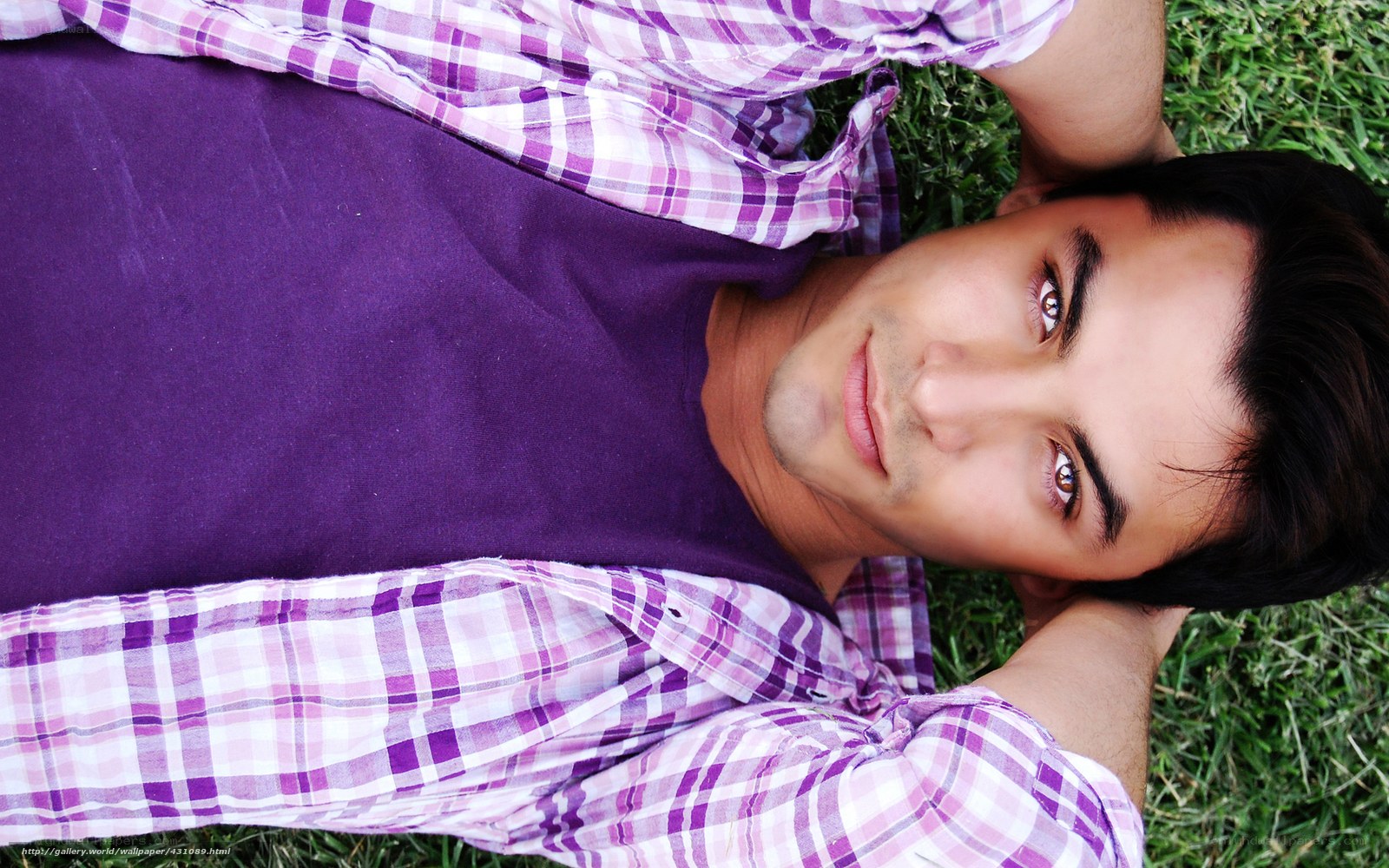 man lying on grass in purple shirt