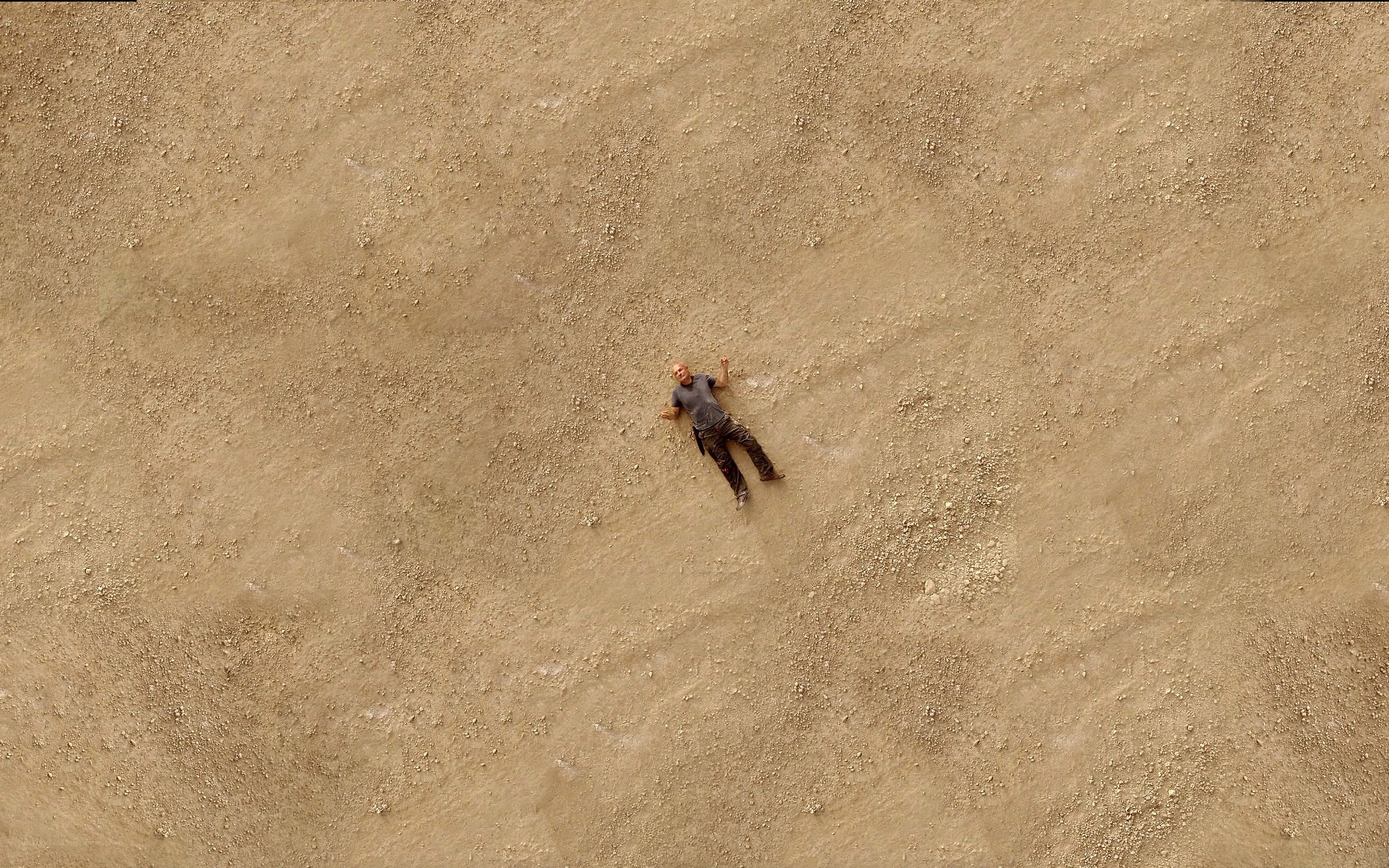 Man lying on sandy ground