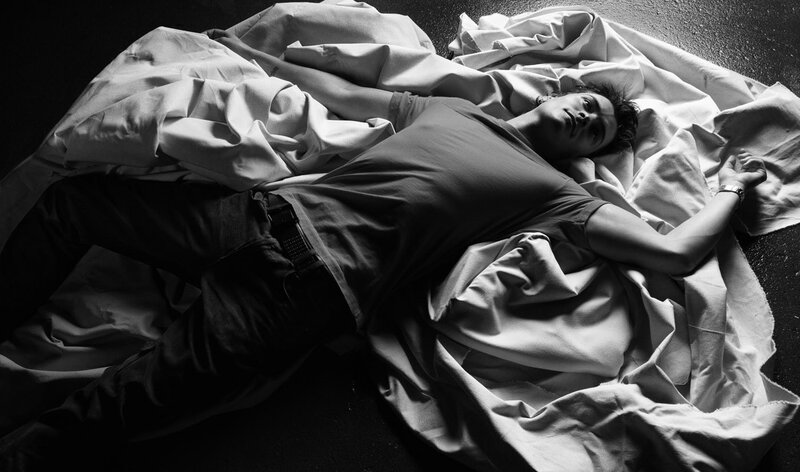 man lying on sheets