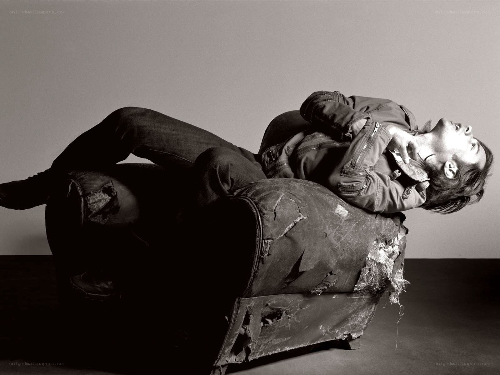 man lying on torn couch