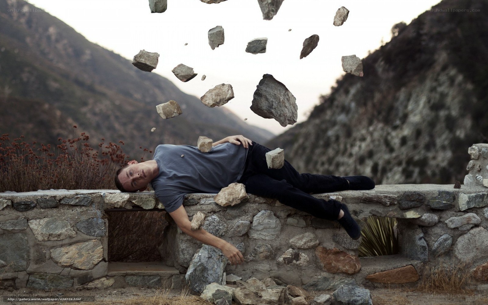 Man lying under falling rocks