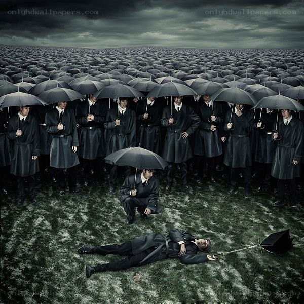 Man lying under umbrella in crowd