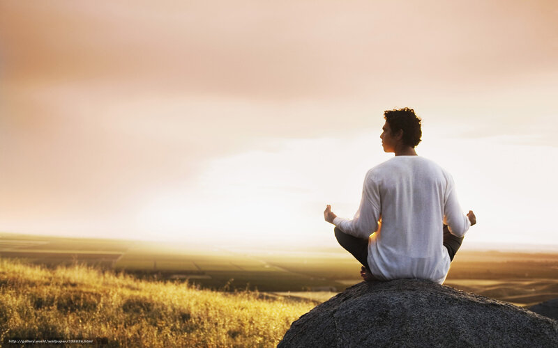 Man meditating at sunset
