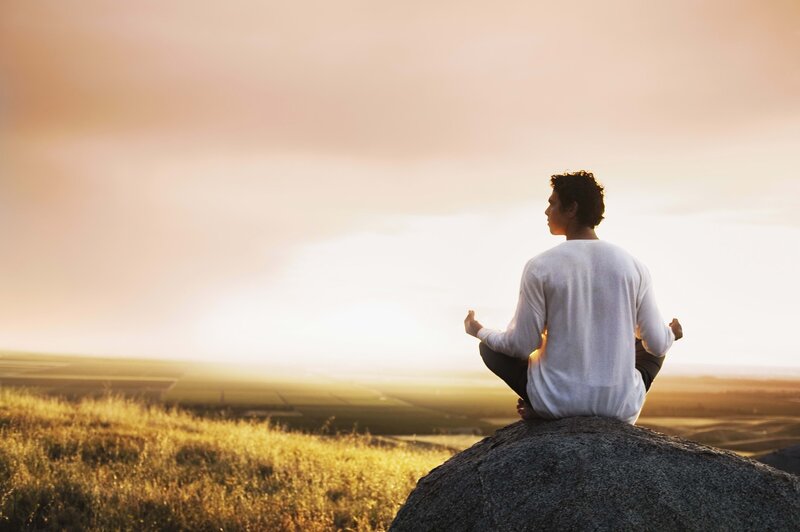 Man Meditating on Rock