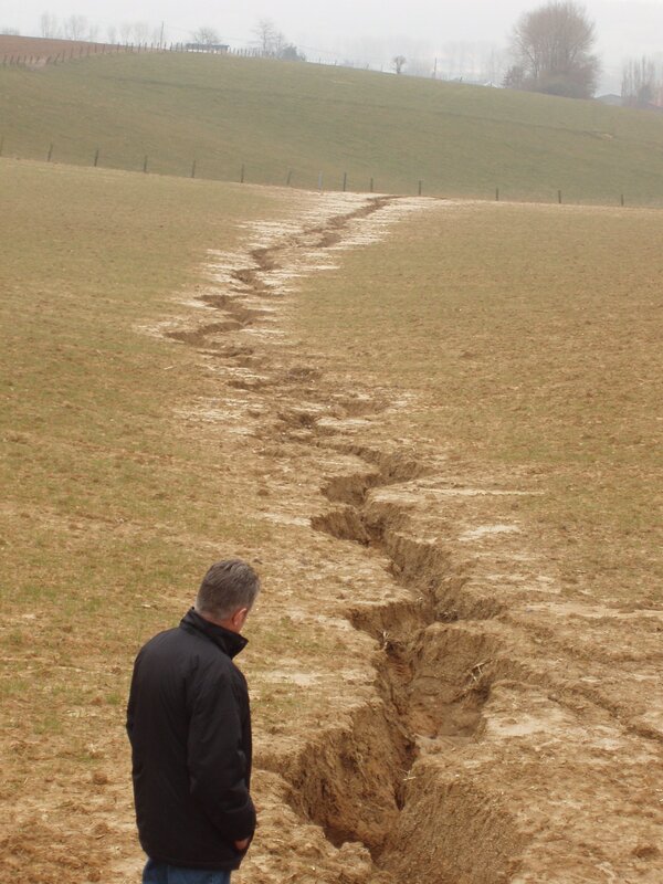 Man observing field crack