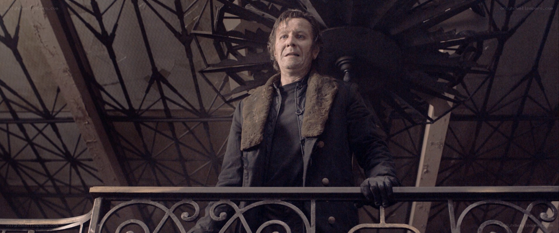 Man on a balcony in a dark setting