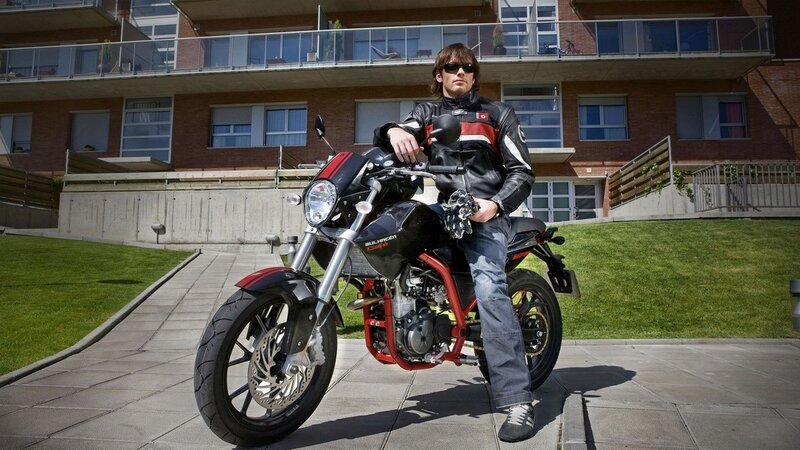 Man on a motorcycle in front of apartment