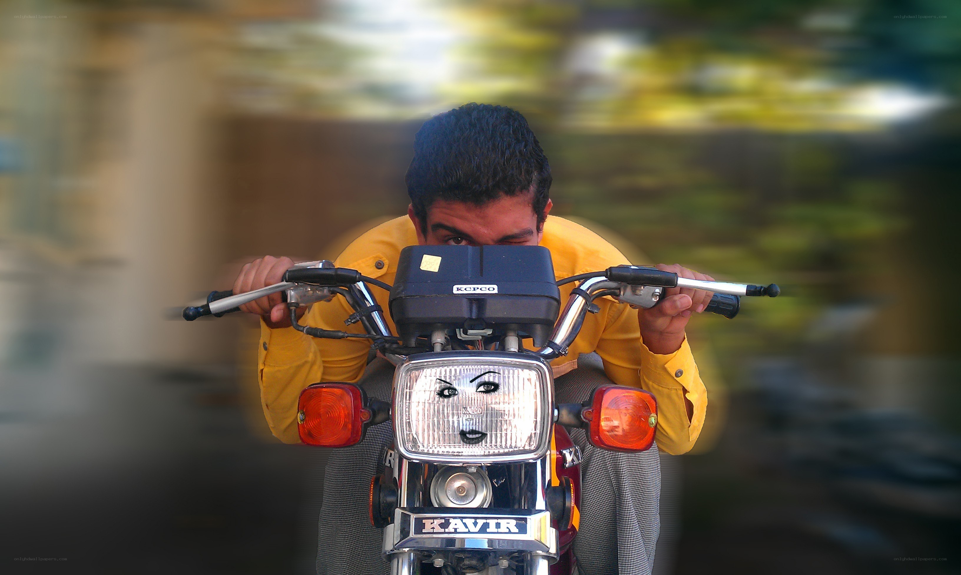 Man on a motorcycle with face on headlight