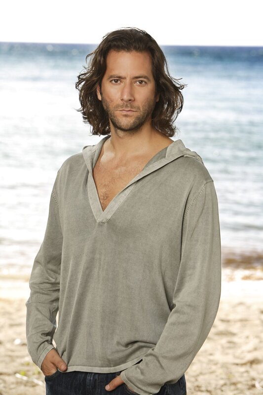 man on beach in hooded shirt