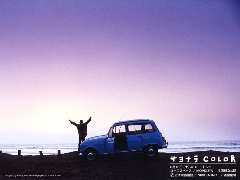 Man on beach with blue car