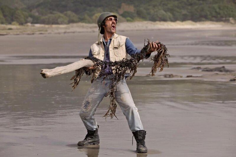 Man on Beach with Driftwood — Brown