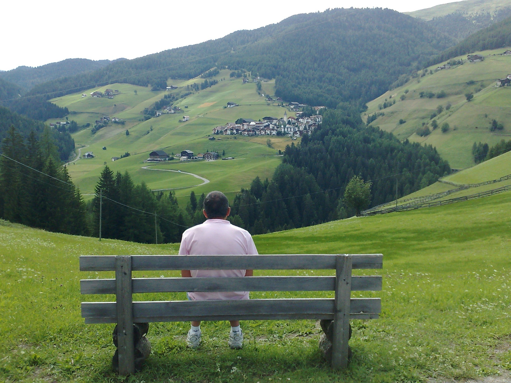 Man on bench overlooking valley