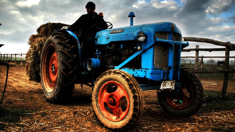 Man on Blue Tractor — Dramatic