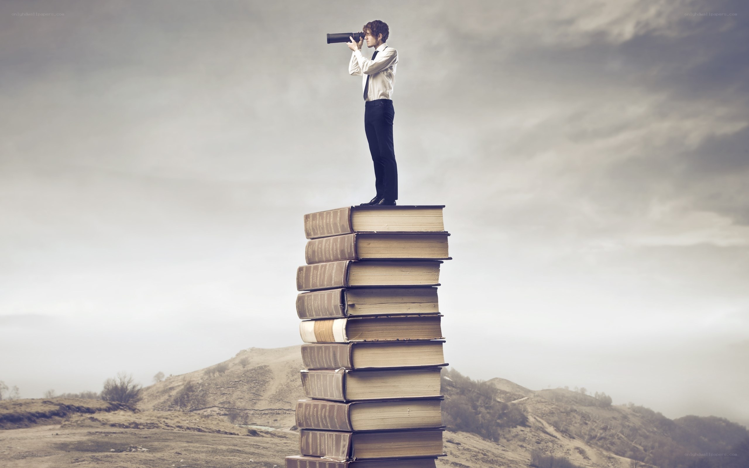 man on books with binoculars