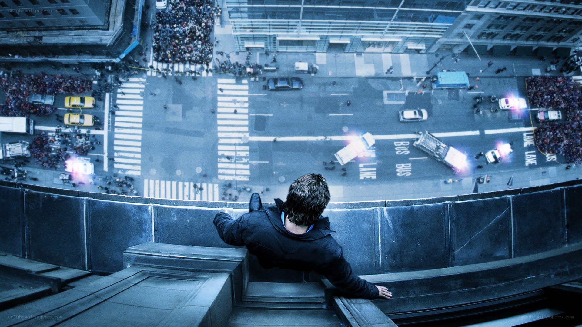 Man on building ledge above city