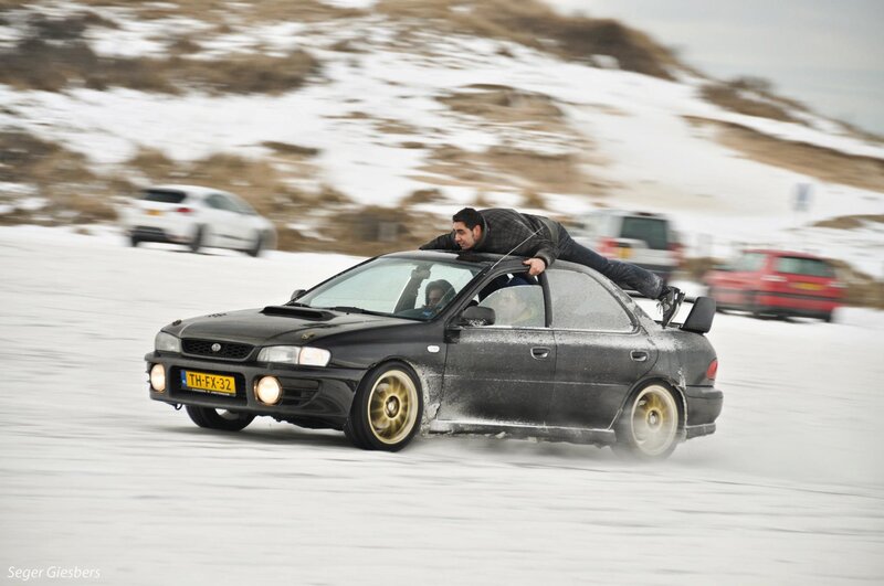 Man on car roof in snow