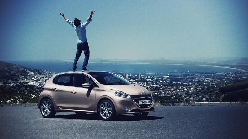 Man on car roof with city view