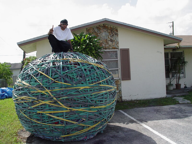 Man on giant rubber band ball