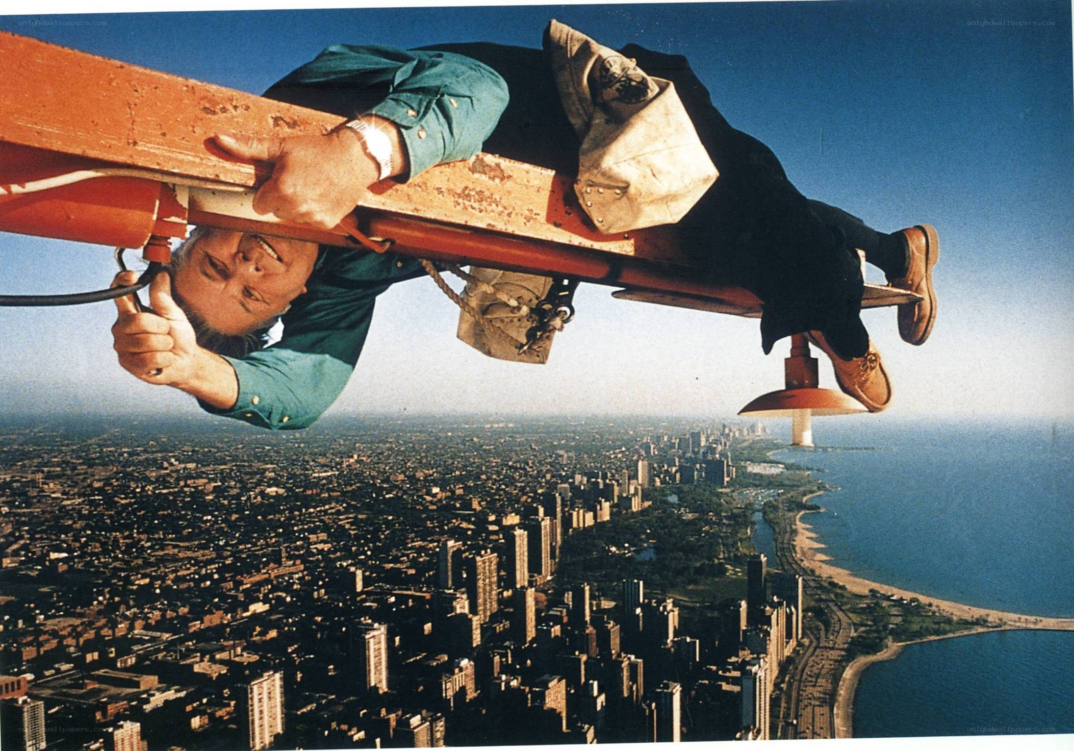 Man on high beam over city