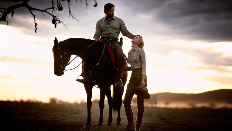 Man on horse with woman at sunset