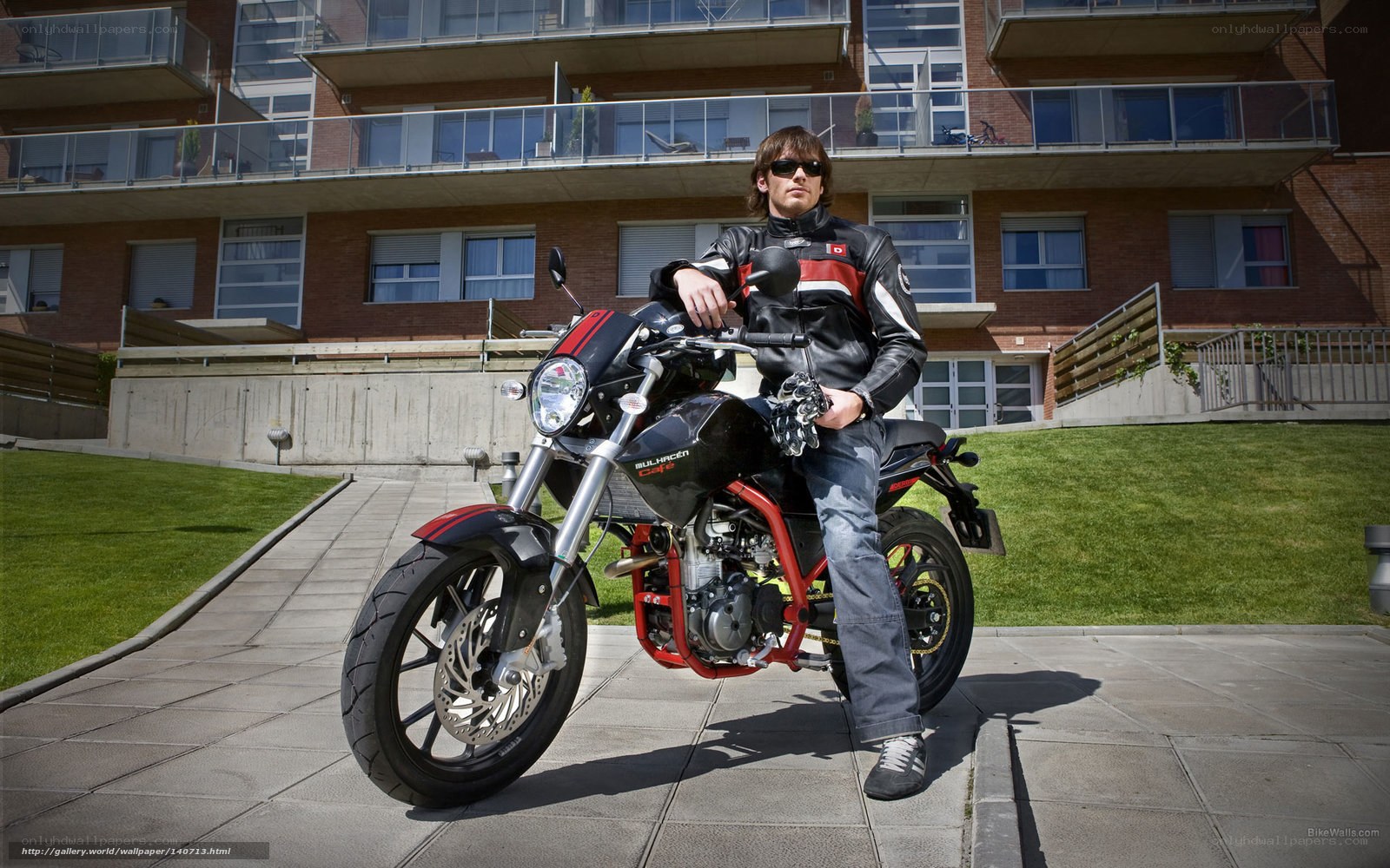 man on motorcycle in front of building